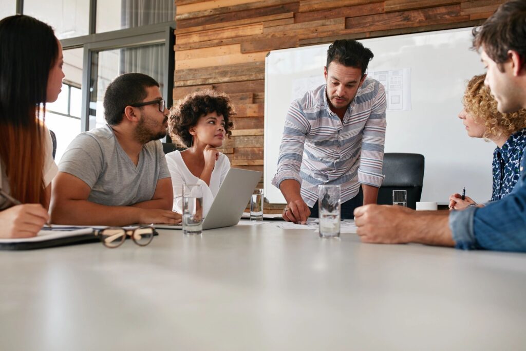 The project manager and the product manager discuss the product vision with the lead product development product team member.